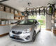 Garage résidentiel bien aménagé avec une voiture au centre, des rangements muraux, des étagères, des bacs et un espace de circulation dégagé.