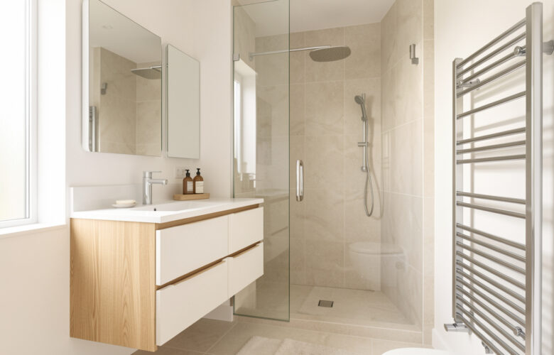Salle de bain moderne et lumineuse avec meuble vasque, douche vitrée, rangements intégrés et sèche-serviettes contemporain.